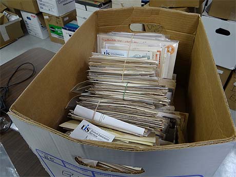 Box of postmarks being processed at PMCC Museum Work Week